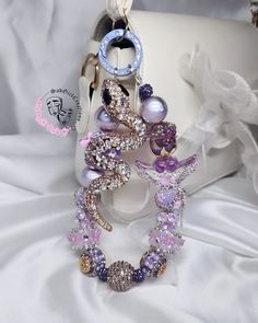 the bracelets are decorated with swarovs, pearls and other jewelry items on a white cloth