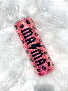 a pink and black glittered can with the word panda on it sitting on a white furry surface