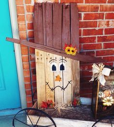 a wooden pallet with a scarecrow face on it sitting in front of a door