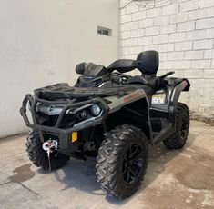 the can - am outlander is parked in front of a brick wall and door