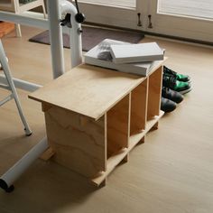 a wooden table with two books on it next to a pair of shoes and a ladder