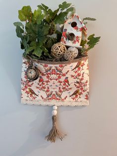 a bird house with plants in it hanging on the wall