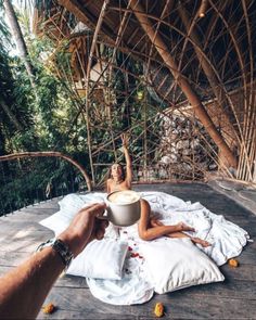 a woman laying on top of a bed next to a cup of coffee