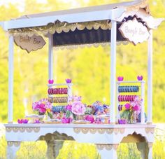 an old fashioned candy bar with flowers and candles on the table in front of it