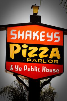 the sign for shakey's pizza parlor is lit up in red and yellow