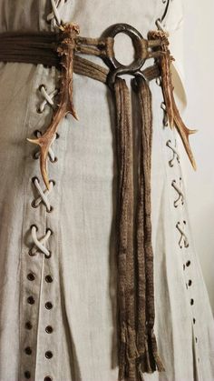 the belt is adorned with deer antlers and leathers, which are tied together