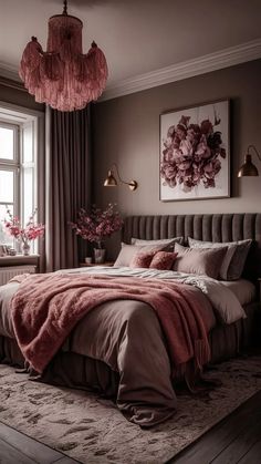 a bedroom with a large bed covered in pink blankets and pillows next to a window