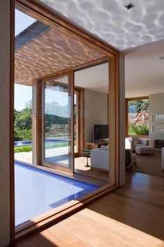 an open living room with sliding glass doors leading to the pool and outdoor area in the background