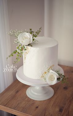 a white wedding cake with flowers on top