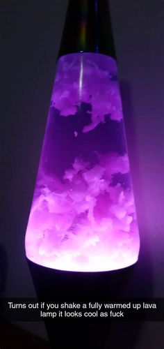 a purple vase sitting on top of a table next to a black light with the words, turns out you shake a fully warmed up lava lamp it looks cool