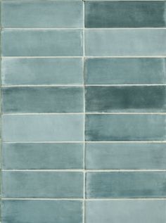 a tile wall with several different shades of gray and white tiles on it's sides