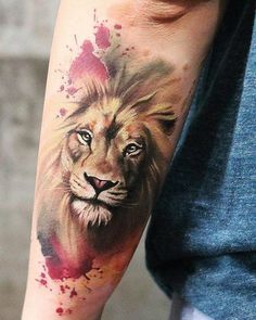 a man's arm with a watercolor tattoo of a lion on the left forearm