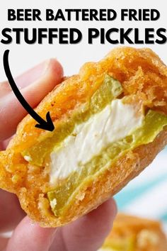 a person is holding a fried pickle in their hand with the text beer battered fried stuffed pickles