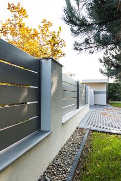 an outdoor area with gravel, rocks and plants on the side of the fenced in area