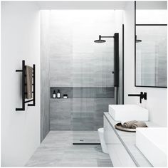 a white bathroom with two sinks and a walk - in shower next to a toilet