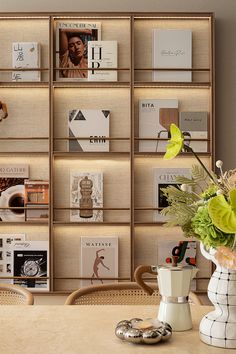 there is a vase with flowers on the table next to bookshelves and magazines