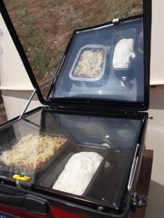 two pizzas are being prepared in an open box