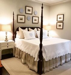 a bed with white sheets and pillows in a bedroom next to two lamps on either side of the bed