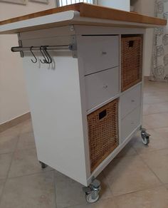 a kitchen island with wicker baskets on the top and bottom drawers, in front of a window