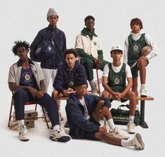 a group of young men sitting next to each other in front of a white background