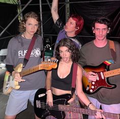 a group of young people standing next to each other holding guitars