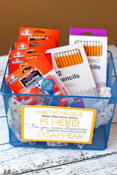 a blue container filled with school supplies on top of a wooden table