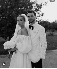 a man and woman in formal wear posing for a photo on their wedding day at the park