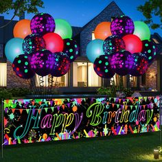 a birthday banner with balloons and confetti on it in front of a house