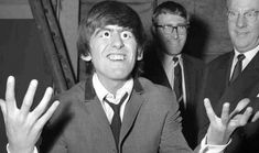 three men in suits and ties are posing for the camera with their hands raised up