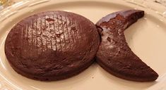 two chocolate cookies sitting on top of a white plate