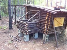 a log cabin in the woods with lots of logs