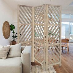 a living room with a white couch and wooden partition