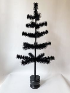 a small black christmas tree on a white background