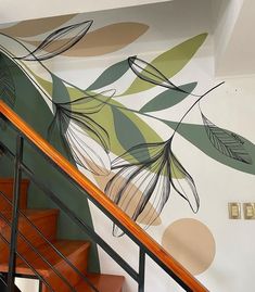 a stair case with leaves painted on the wall