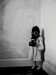 a person wearing a gas mask standing against a wall