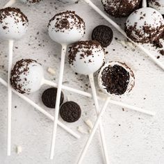 chocolate cake pops and oreo cookies on a white surface with sprinkles