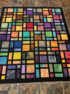 a multicolored patchwork quilt on the floor