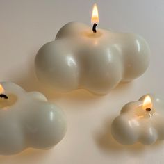 three white candles sitting next to each other