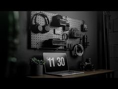 a laptop computer sitting on top of a wooden desk next to a camera and headphones