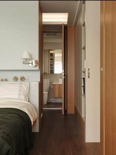 a bedroom with wood floors and white walls