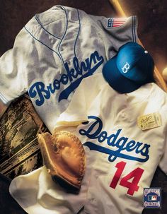 the dodgers baseball uniform is laying next to a bat and glove on top of a table