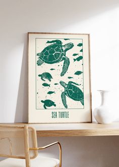 a framed sea turtle poster sitting on top of a wooden table