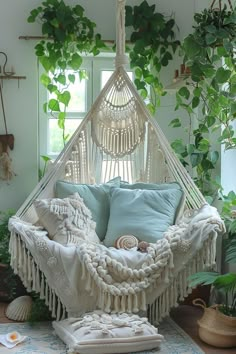 a white hammock hanging from the ceiling in a room filled with potted plants