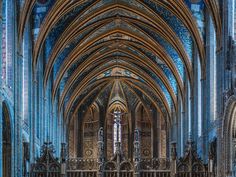 the inside of a large cathedral with blue and gold paint on it's walls