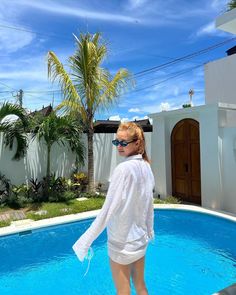 a woman standing in front of a swimming pool