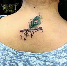 a woman with a peacock feather on her back neck and the word love written in cursive writing