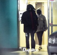 two people are walking into an elevator with their faces covered by the hoods and jackets