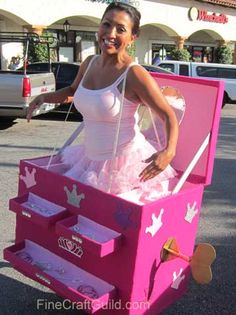 a woman in a pink dress is standing next to a cart with jewelry on it