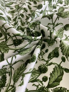 the fabric is green and white with leaves on it's back side, as well as