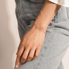 a woman's hand with a tiny diamond bracelet on her left wrist and right arm